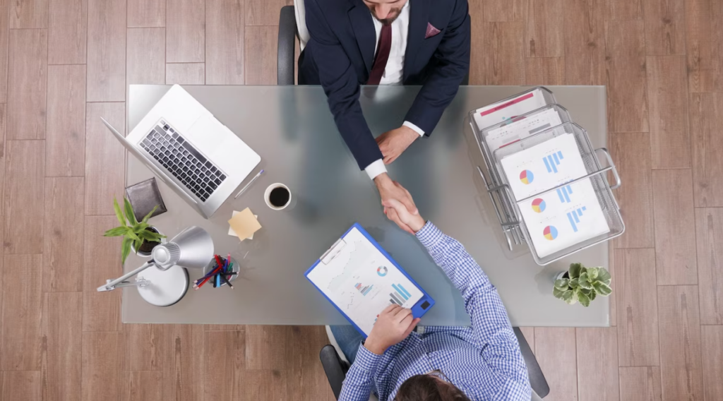 view of businessmen shaking hands during business negotiation in office