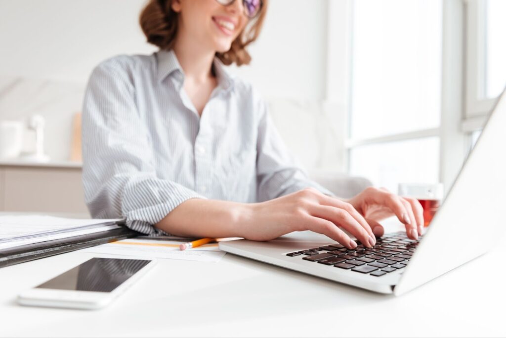 Happy woman typing on laptop