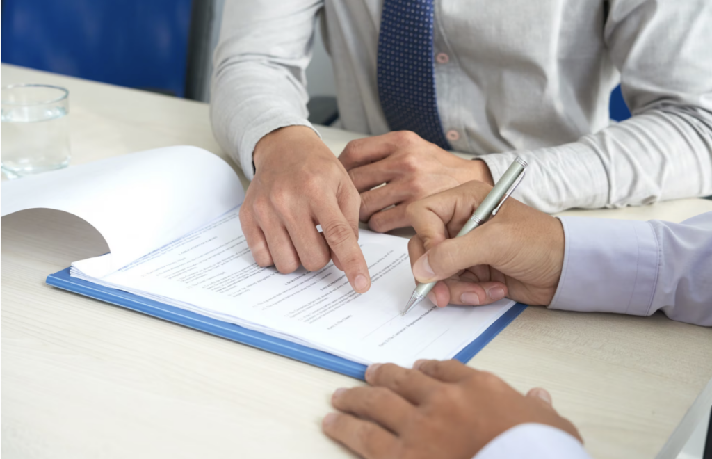 The employee invites the client to sign documents.