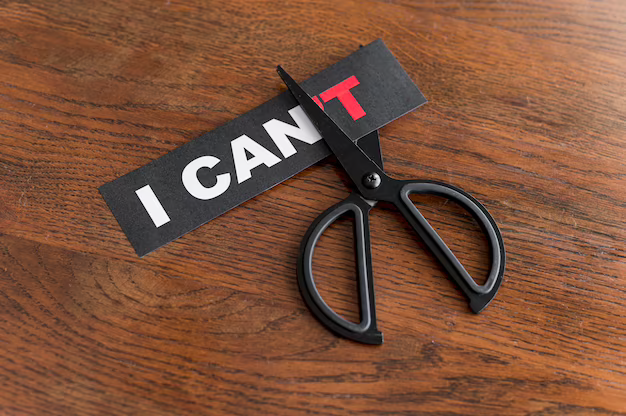 Scissors cutting black paper with the text 'I can't'.