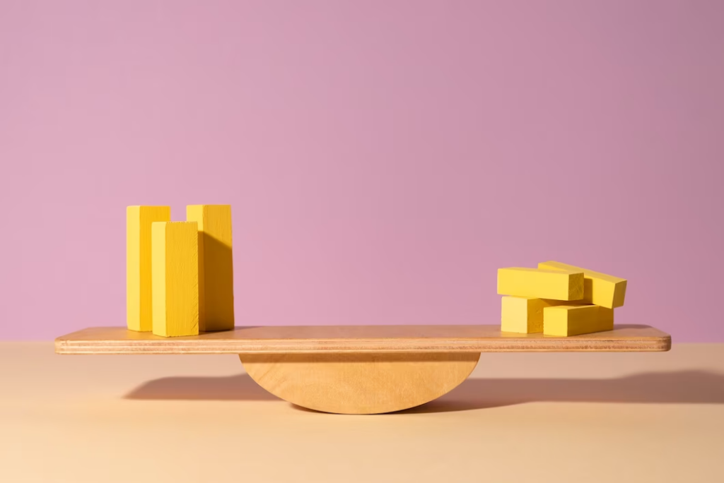 Wooden weighing tool with items on both sides, resembling a balancing scale